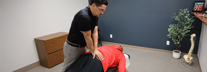 Chiropractor Basehor KS Dennis Lindsay Adjusting Patients Lower Back