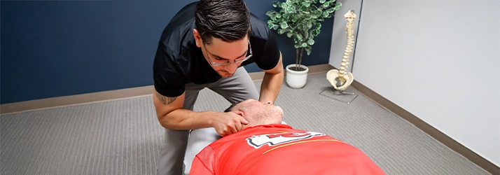 Chiropractor Basehor KS Dennis Lindsay Adjusting Patients Neck