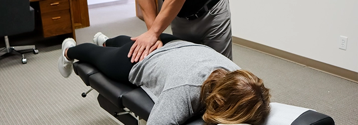 Chiropractor Basehor KS Dennis Lindsay Adjusting Patients Sciatic Area