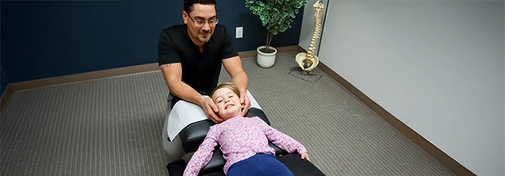Chiropractor Basehor KS Dennis Lindsay Adjusting Pediatric Patient