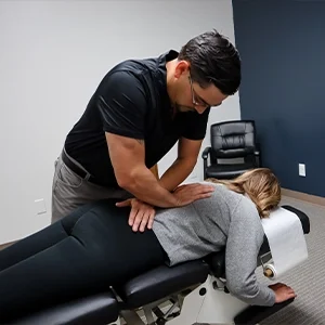 Chiropractor Basehor KS Dennis Lindsay Adjusting Patients Spine